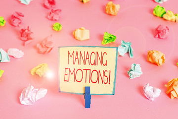 Fototapeta na wymiar Text sign showing Managing Emotions. Business photo text ability be open to feelings and modulate them in oneself Colored crumpled papers empty reminder pink floor background clothespin