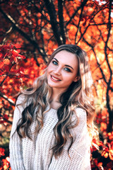 Beautiful smiling woman enjoying autumn in the forest.