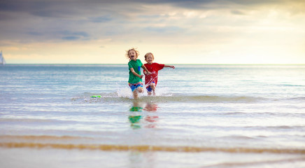 Kids play on tropical beach. Sand and water toy.