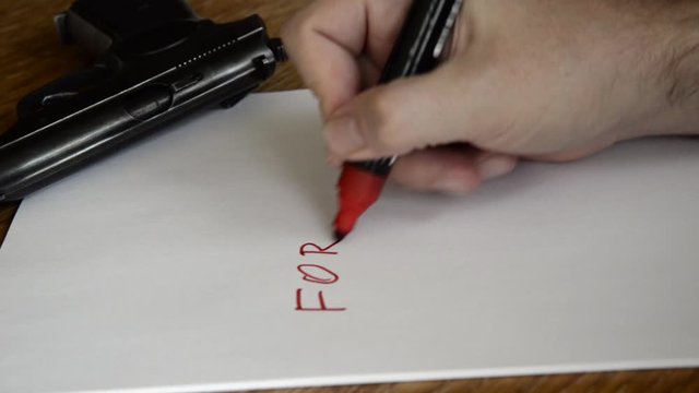 A man is writing a suicide note and take a gun