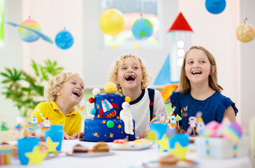 Kids space theme birthday party with cake.