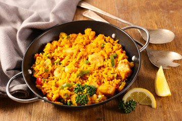 paella with seafood, spanish dish on wood background