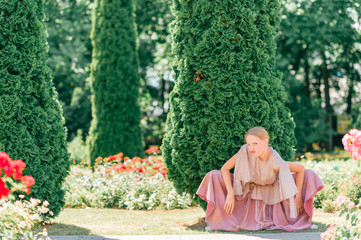 Funny portrait of ballerina posing with foolish face in botanical garden