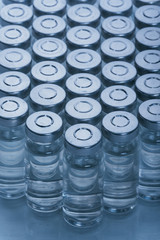 Glass medical ampoule vial for injection. Medicine is dry white drug penicillin powder or liquid with of aqueous solution in ampulla. Close up.