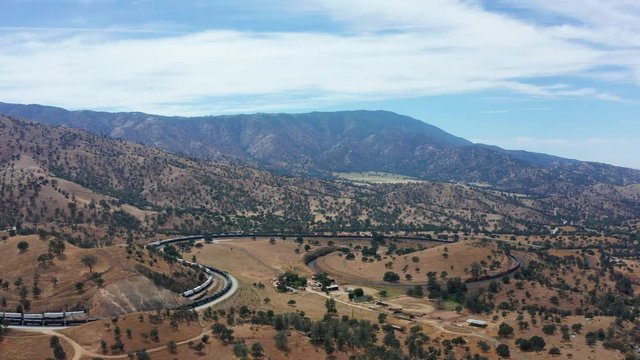 Aerial view of train traveling on railroad around Tehachapi Loop