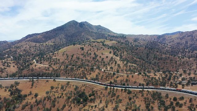 Aerial view of long train traveling on Tehachapi railroad