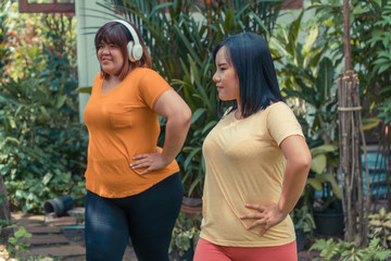 Overweight Asian women workout in the garden with her friend. Concept of Exercise to lose weight and maintain good health.
