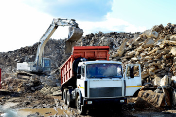 Dump truck unloading of broken concrete slabs demolition waste on landfill. Reuse concrete. Salvaging and recycling building and construction materials. Construction waste crushing and recycling plant