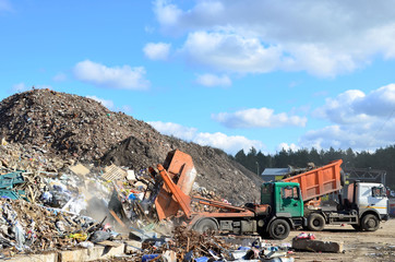 Garbage truck unloads construction waste from container at the landfill. Construction garbage process, concrete recycling, crushing and recycling of construction mixed waste and demolition material