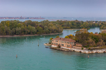 Certosa island with autumn-colored trees and the island of Murano in the background, Venice, Italy