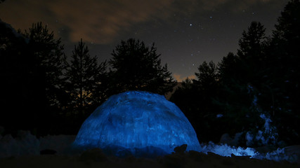 Igloo at night scene. Winter landscape glowing by star light