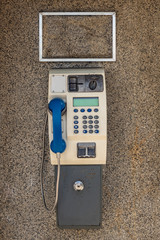 Dirty street telephone in a cabin
