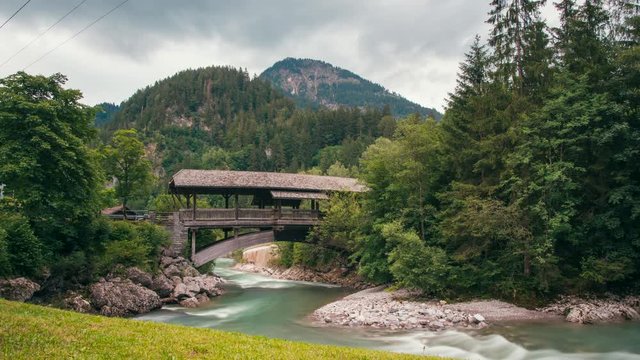 Restful Keep Calm Time-lapse of Mountain River with Wooden Bridge and Trees at Summer Sunset. Fabulous 4K Static Background Video from Alps in Hinterstein, Allgau, Germany