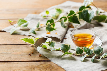 Cup of hot green tea on a wooden table