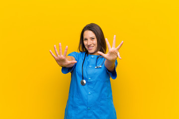 smiling and looking friendly, showing number nine or ninth with hand forward, counting down...