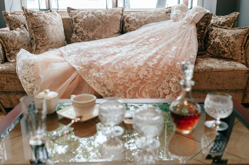 White weeding dress lying on bed in hotel.