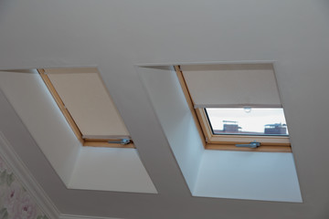 Attic window. Curtain on the roof window. Jalousie.