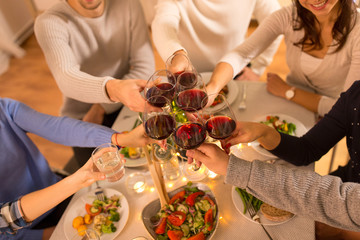 celebration, holidays and people concept - happy family having dinner party, drinking red wine and...
