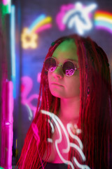 Girl in neon lights, beautiful woman in sunglasses, with pink hair, with dreadlocks pigtails, bright and stylish in glow of neon signs