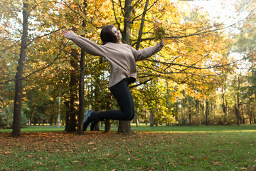 Dziewczyna skacze z radości w parku.