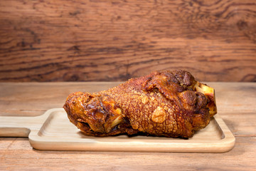 fried pork leg cooked on wood background