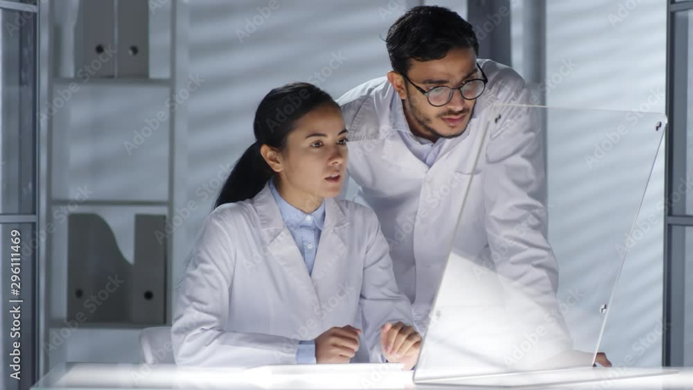 Poster asian female doctor and middle eastern male practitioner using transparent multi-touch screen of fut