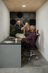 Two entrepreneurs high five in cubicle workstation coworking office space