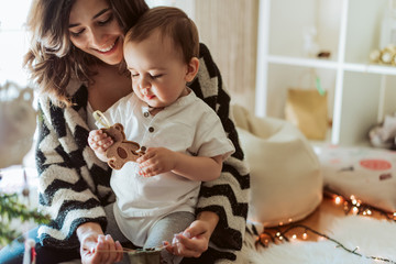 Mother and baby playing around the Christmas Tree