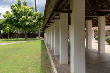 The grass field in the ancient Thai temple has a tree surrounded. And there are many colors of fabric around Buddhist belief in Asia.