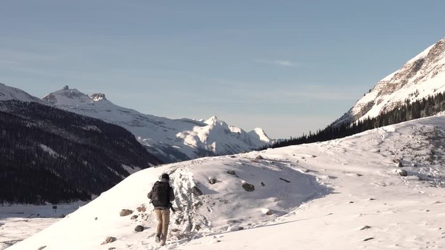 Backpacker hiking during the winter in the snowed mountains of Canada.