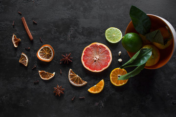 sliced fresh and dry citruses grapefruits, tangerines and lime with cinnamon and star anise on a...