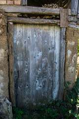 Old grungy door, door handle close-up, damaged wooden door texture