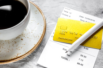 restaurant bill, card and coffee on stone table background