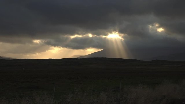 Dramatic cloudbreak light beams over Icelandic farmland.mov