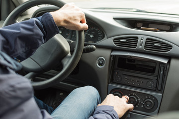 Hands of a driver on steering wheel of a car.