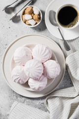Pink marshmallows with blackcurrants on a plate. Light gray background