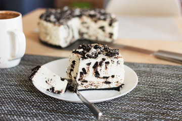 Unbaked creamy cheesecake with chocolate cookies and cream biscuits.