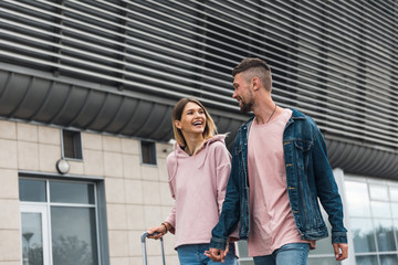 Couple tourists with suitcases walking on street