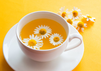 Herbal tea with fresh chamomile flowers in a cup