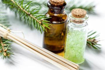 spa with organic spruce oil and sea salt in glass bottles on white table background