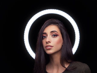 Beautiful young caucasian woman trendy look portrait with ring light halo black background for...