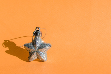 Christmas tree star shaped toy on orange background. copy space