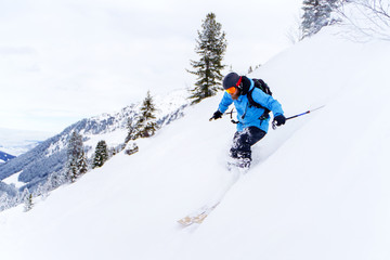 Naklejka na ściany i meble Image of sports man with beard skiing in winter resort