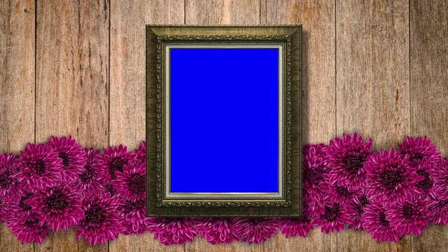 Vintage picture frame with purple flowers on wooden wall background