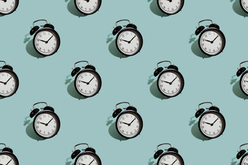 Many black classic style alarm clock isolated on green background
