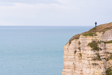 Un homme sur une falaise de Normandie. Une silhouette au bord d'une falaise de Fécamp. Penser au...