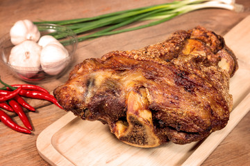 fried pork leg cooked on chopping block