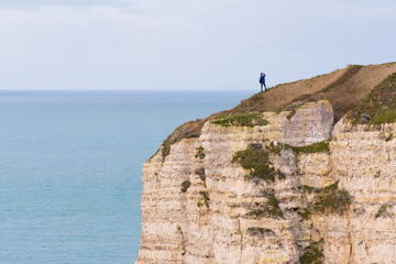 une personne sur les falaises de Normandie à Etretat regarde l'océan