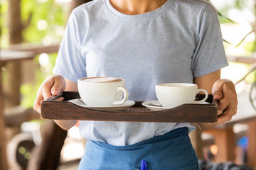 female waitress hold coffee tray gently