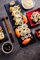  Sushi Set Sashimi und Sushirollen auf Steinschiefer serviert